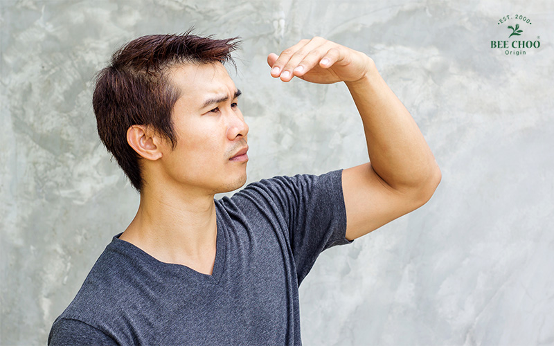 Why Do I Have Dandruff? Reasons and How to Stop It 3 A man looking up and shielding his eyes.