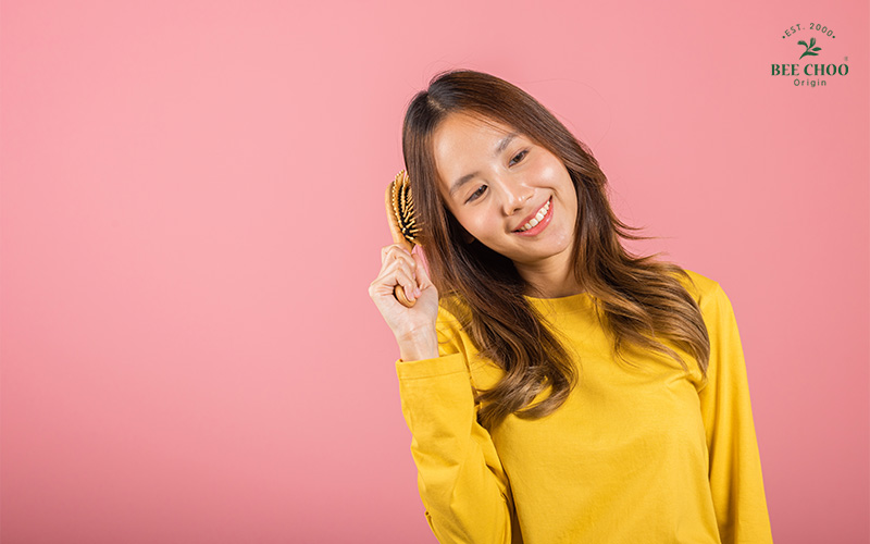 Happy woman brushing her hair.