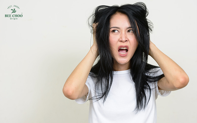A woman scratching her hair.